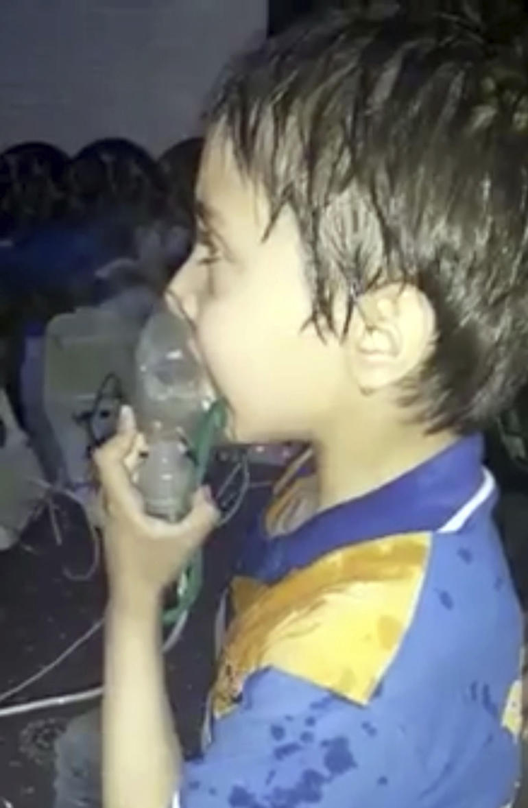 This image made from video released by the Syrian Civil Defense White Helmets, which has been authenticated based on its contents and other AP reporting, shows a medical worker giving toddlers oxygen through respirators following an alleged poison gas attack in the opposition-held town of Douma, in eastern Ghouta, near Damascus, Syria, Sunday, April 8, 2018