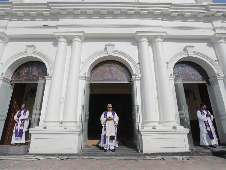 Sri Lanka priests outside St Anthony's church a year on AP Photo by Eranga Jayawerdena.jpg