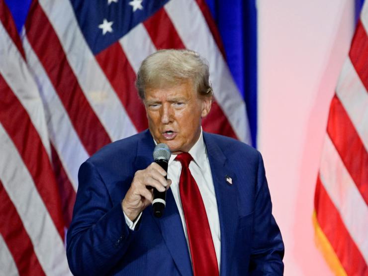 Trump speaking US flag background.JPG
