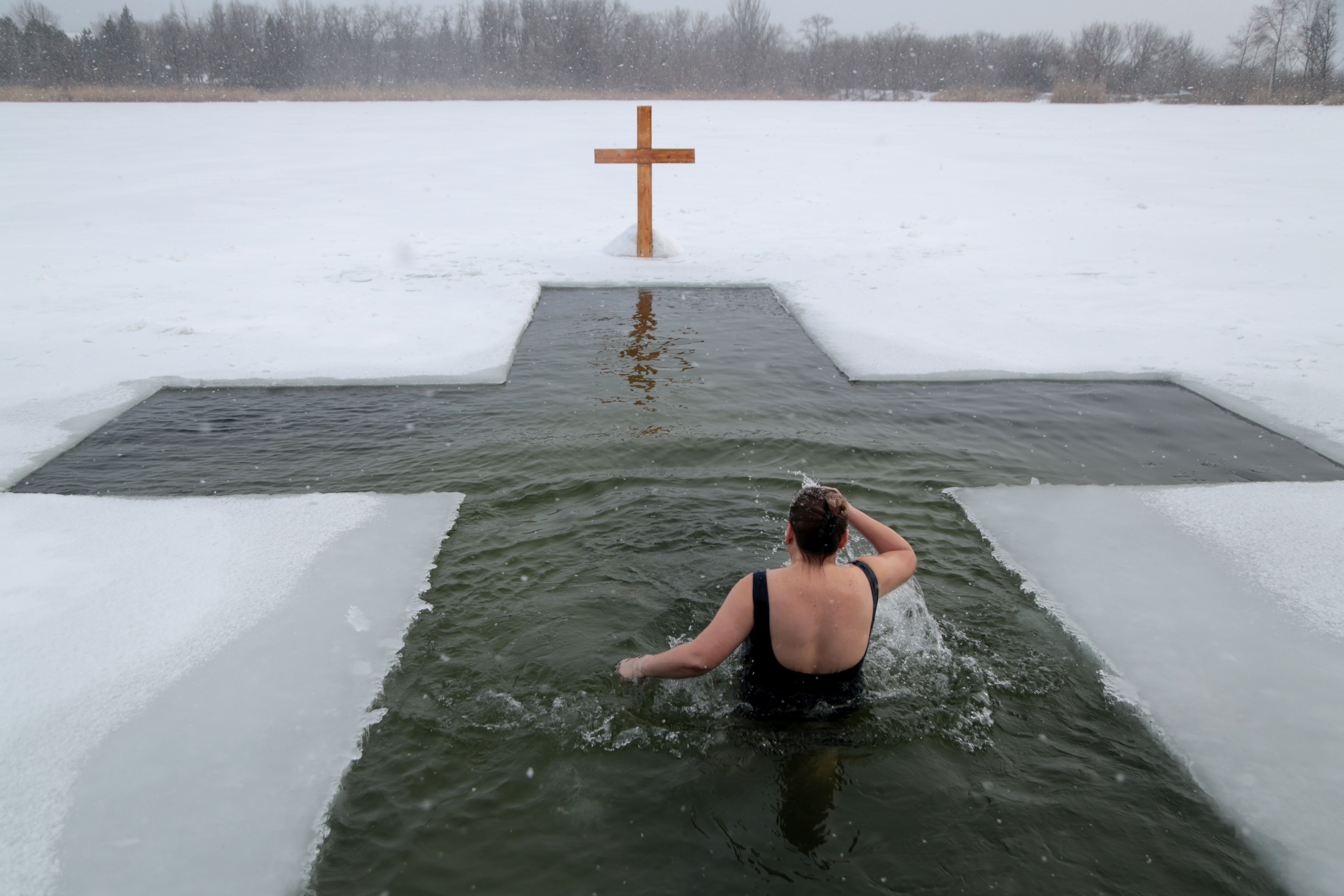 Photos show Orthodox Christians plunging into icy depths to mark Epiphany