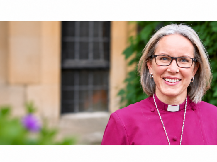 Smiling Clergywoman Among Purple Flowers.png