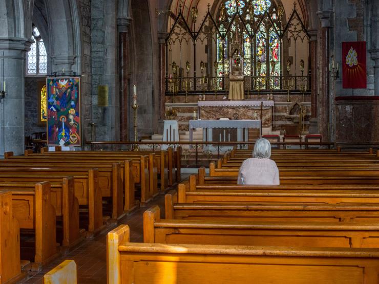 Lone elderly person in church.jpg